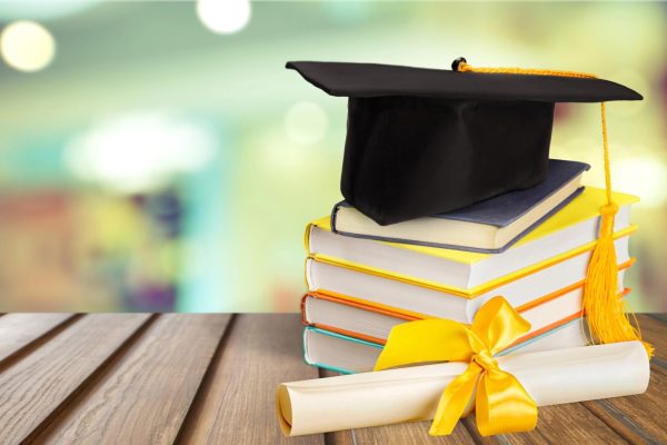 graduation cap on books